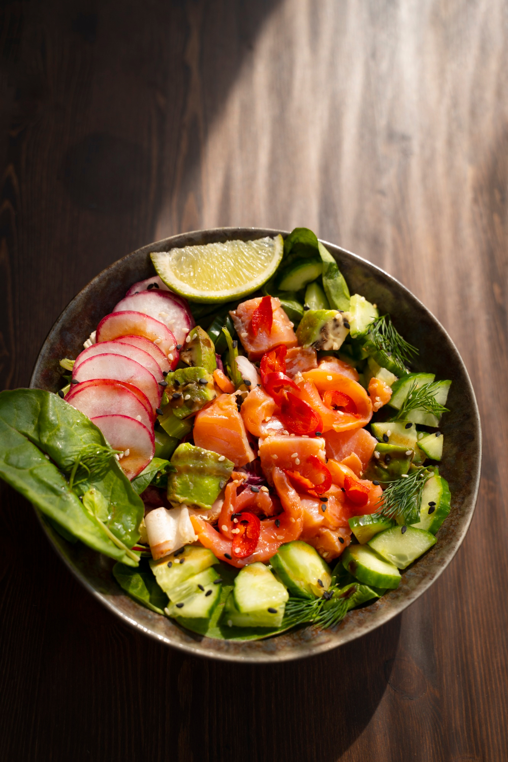 A close-up salmon salad bowl highlights a low-carb meal pattern that can change how nighttime recovery feels.