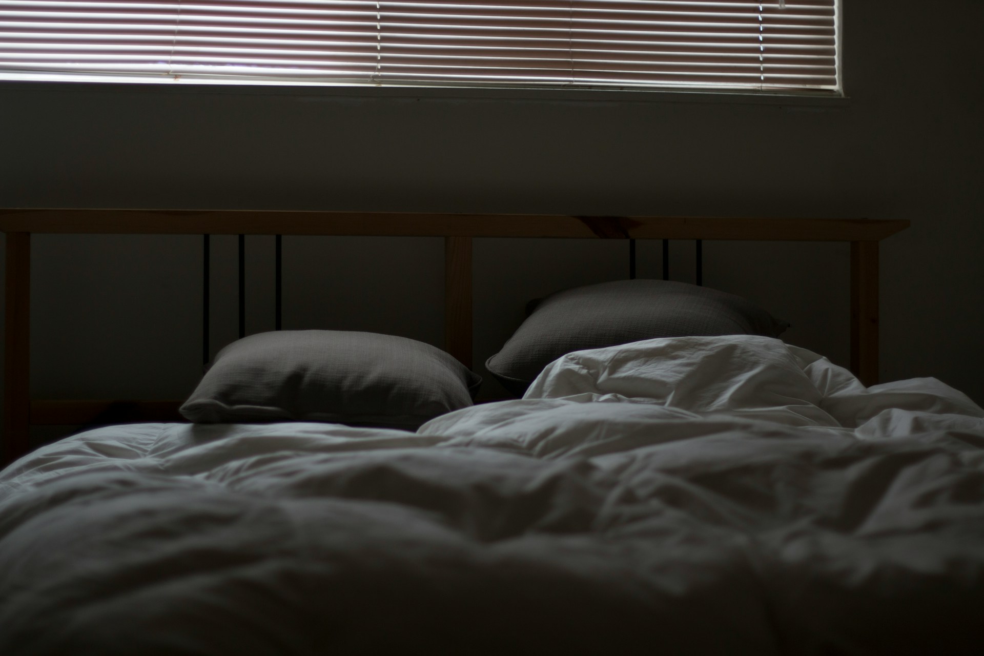 A calm bedroom with dim warm light and a slightly open window showing night sky