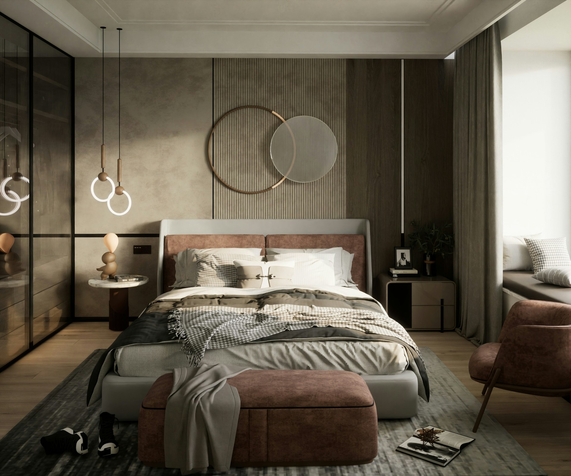 A modern bedroom with a large bed covered in layered blankets and pillows, set against a textured wall with circular decorative mirrors. The room features warm lighting from pendant lamps, a cozy seating area with a pink chair and ottoman, a bedside table with a plant and framed photo, and a window seat with cushions. The atmosphere feels calm, inviting, and restful, suggesting a peaceful retreat for relaxation or sleep.