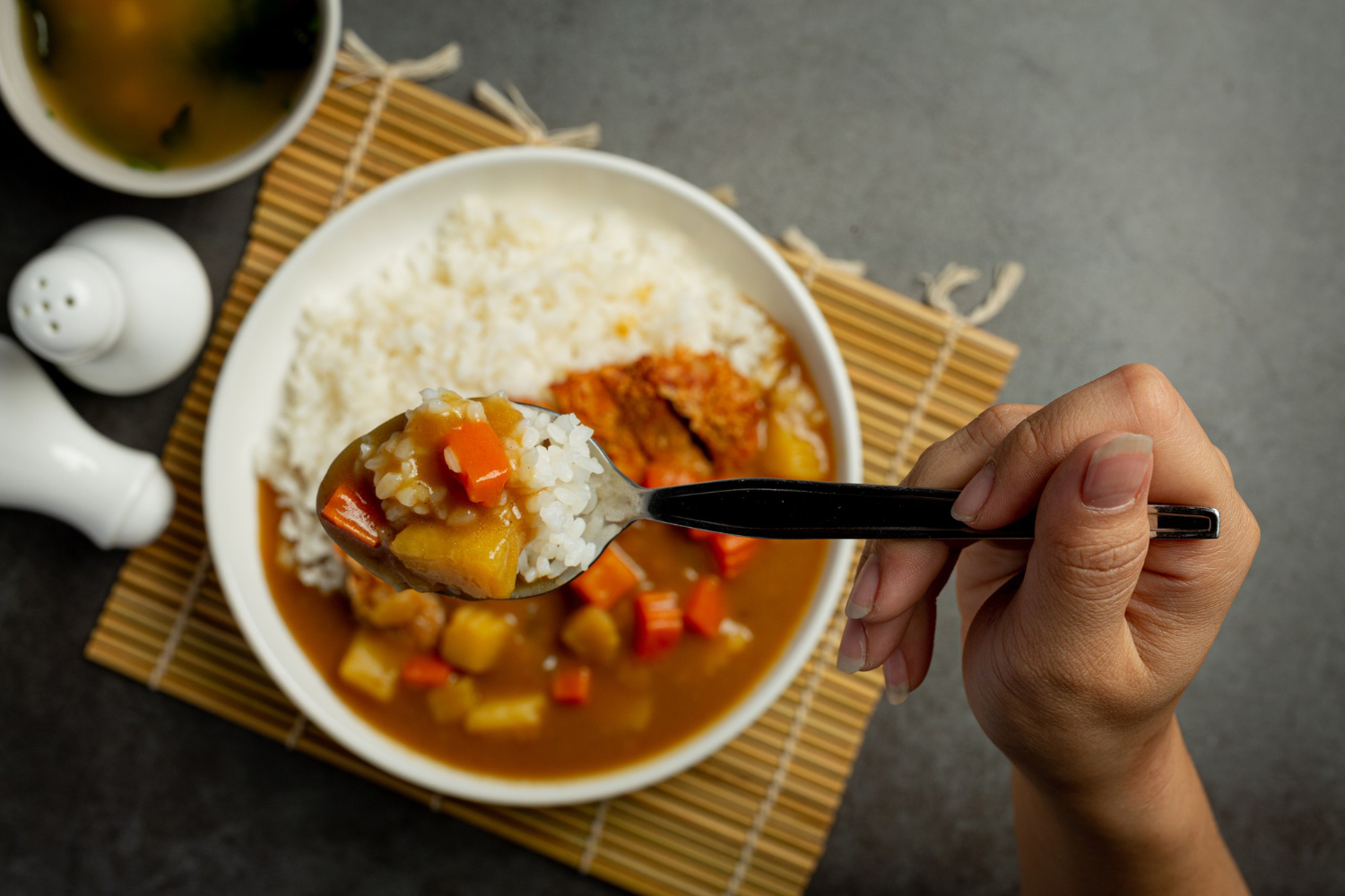 A bowl of rice with curry and vegetables, showing a more substantial carbohydrate-containing meal.