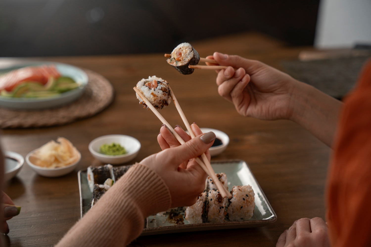 People sharing sushi at dinner, a meal that combines carbohydrate with protein in a lighter format.